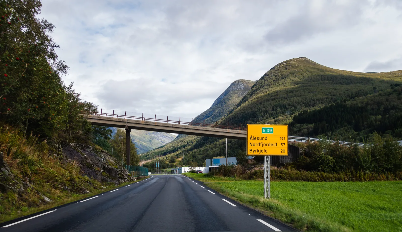 Norsk landevei med veivisningsskilt mot Ålesund, Nordfjordeid og Bryggja